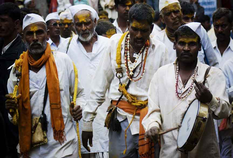 Devotee performing   prayers with  musical instrument during Yatra of Lord Khandoba  at Jejuri tample