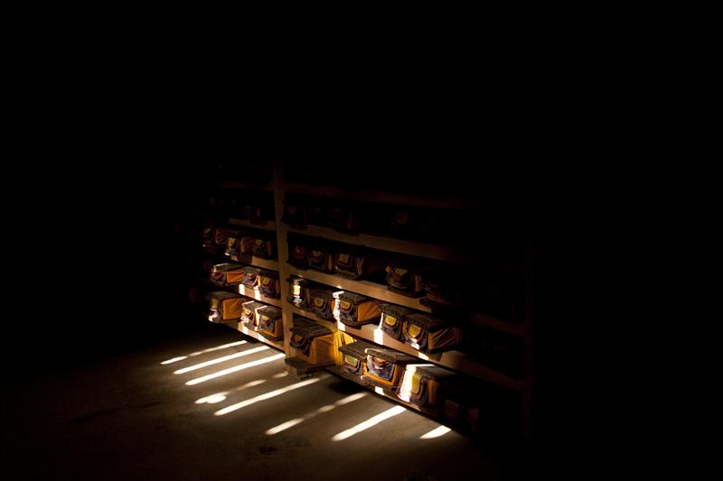 Tibetan prayer texture kept in the monastery as sunrays fall in these dark, dusty rooms.