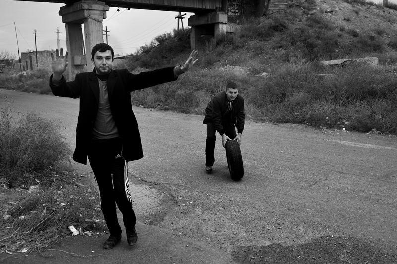 Young men arrive at a petrol station to repair a punctured tyre