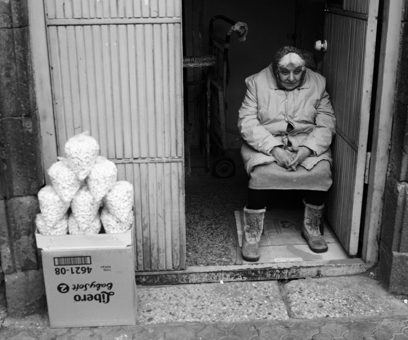 Woman sits inside a roadside shop