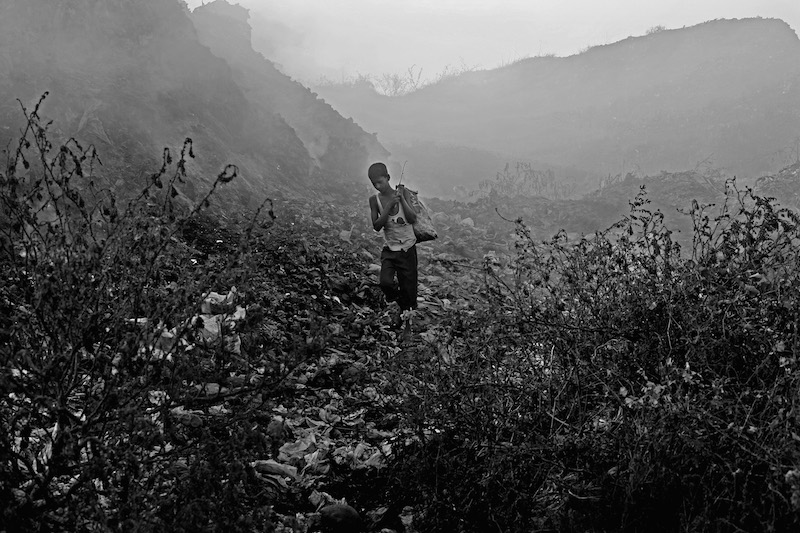 Azgar is walking to sell his collected materials from Anandabazar dump yard in Chittagong.