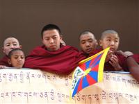 Hopeful monks look their God-king Lama.