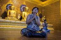 A woman prays in the pagoda of Shwedagon