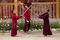 Young monks play with wooden sticks inside the monastery complex in Lo Manthang.