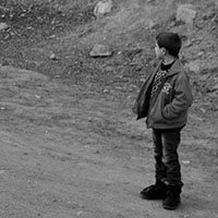 Hay truck passes a boy on the roadside north of Agarak