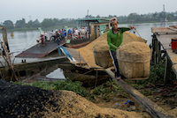 A worker carries a 50kg load of rice husks